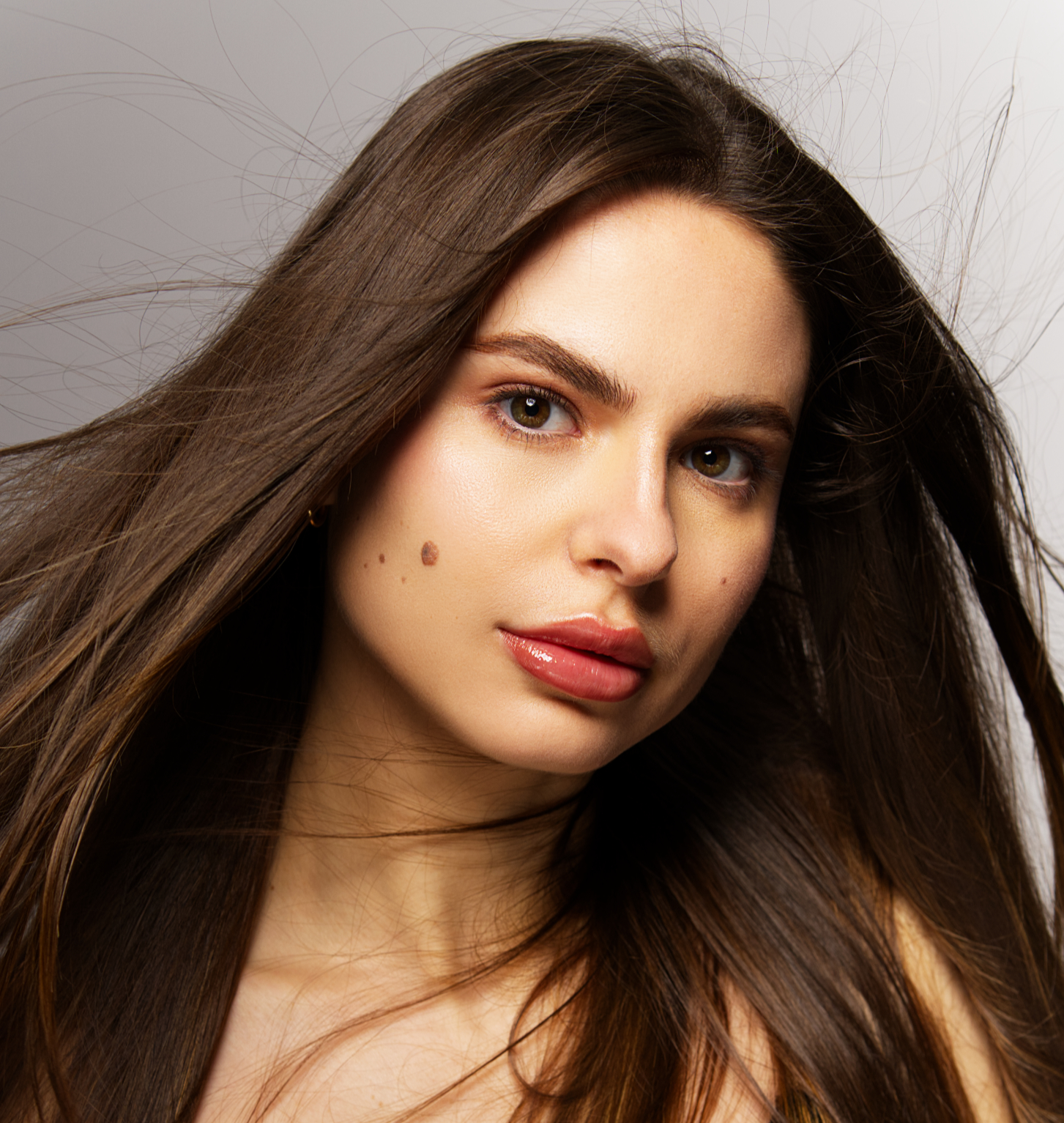 Portrait rapproché, longs cheveux bruns et regard direct