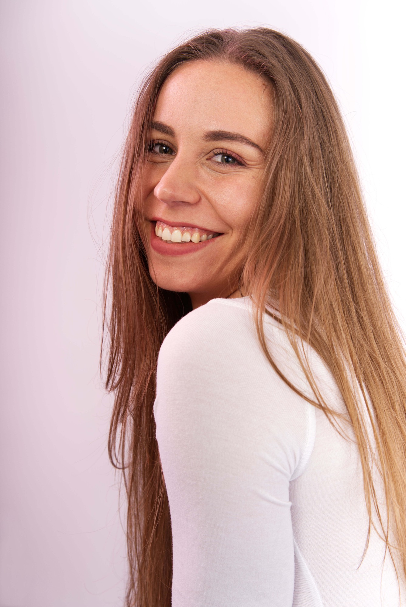 Portrait souriant en lumière douce, haut blanc sur fond clair