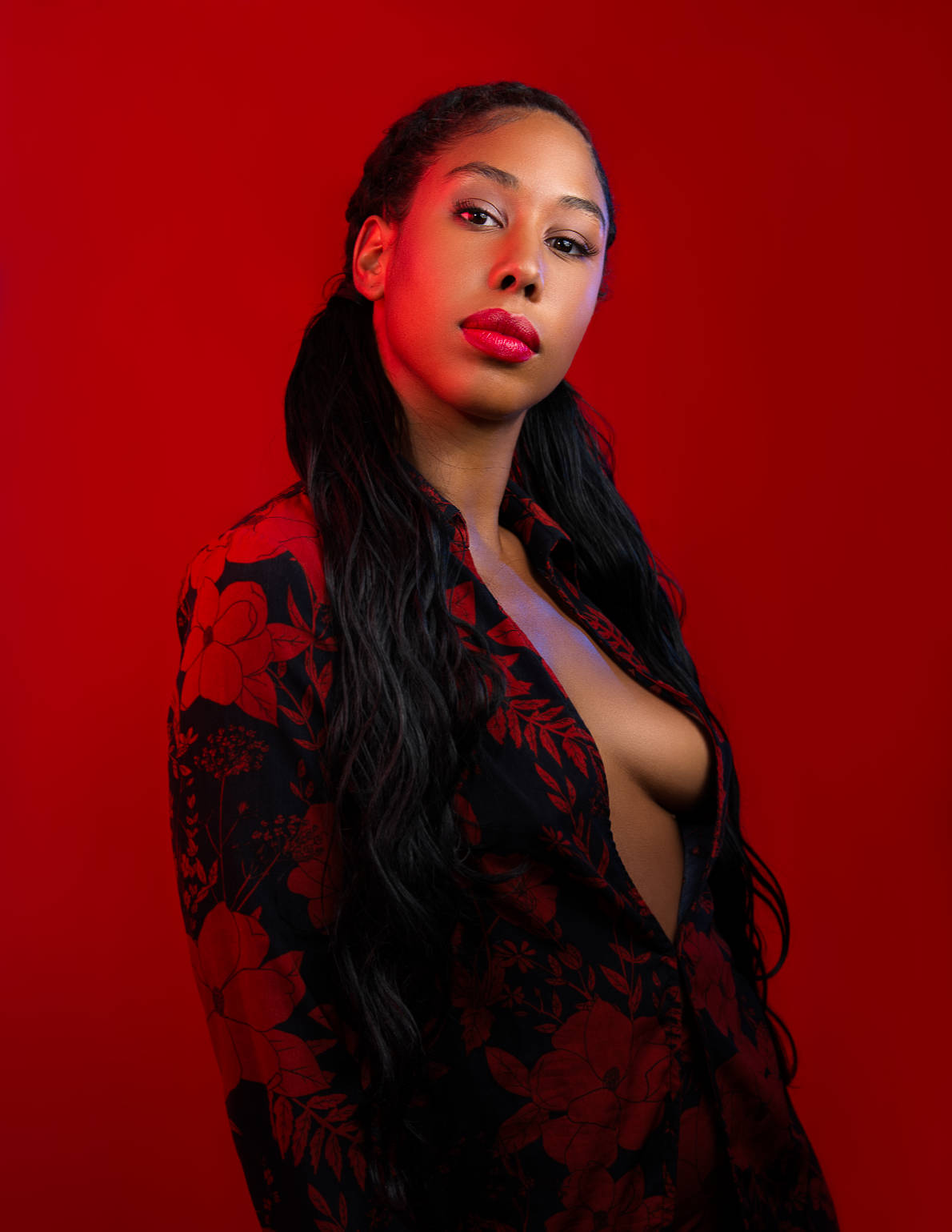 Portrait sur fond rouge, tenue noire à motifs floraux