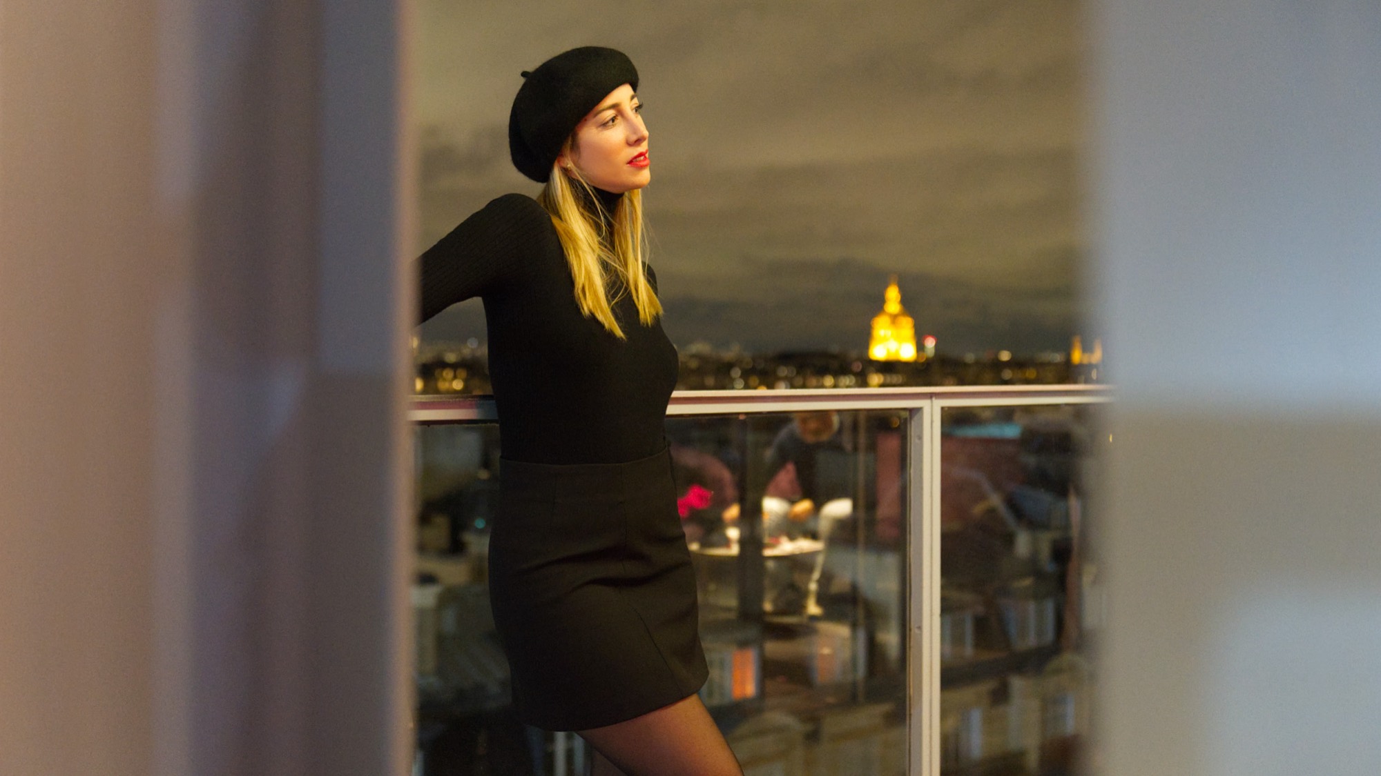 Portrait d'une femme sur un balcon parisien en fin de journée